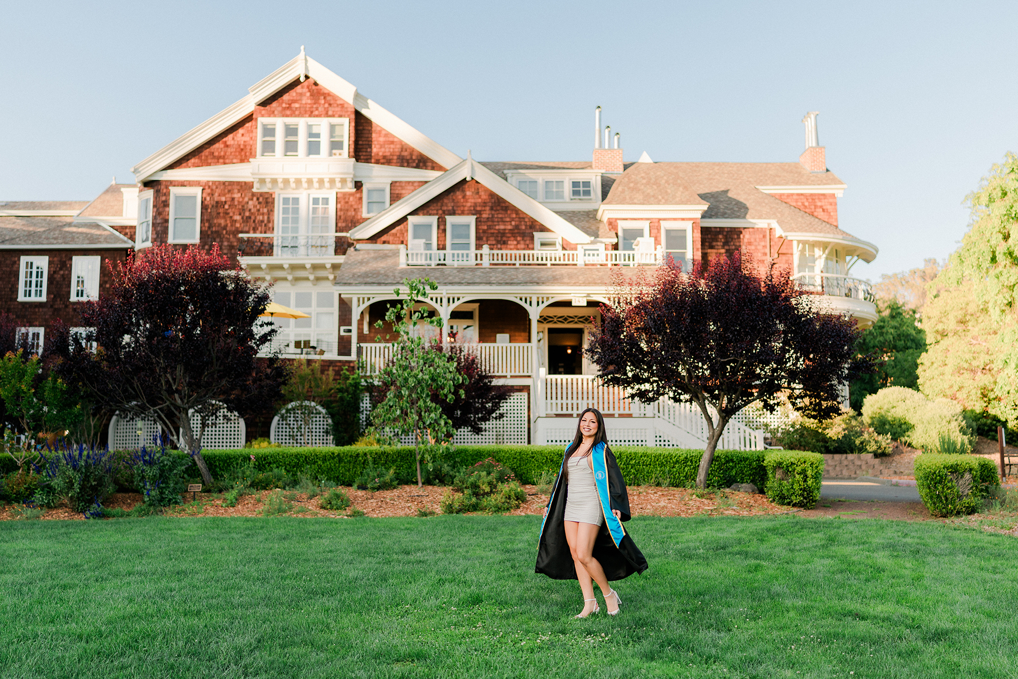 Dominican University nursing graduate standing in front of Meadowlands building on campus