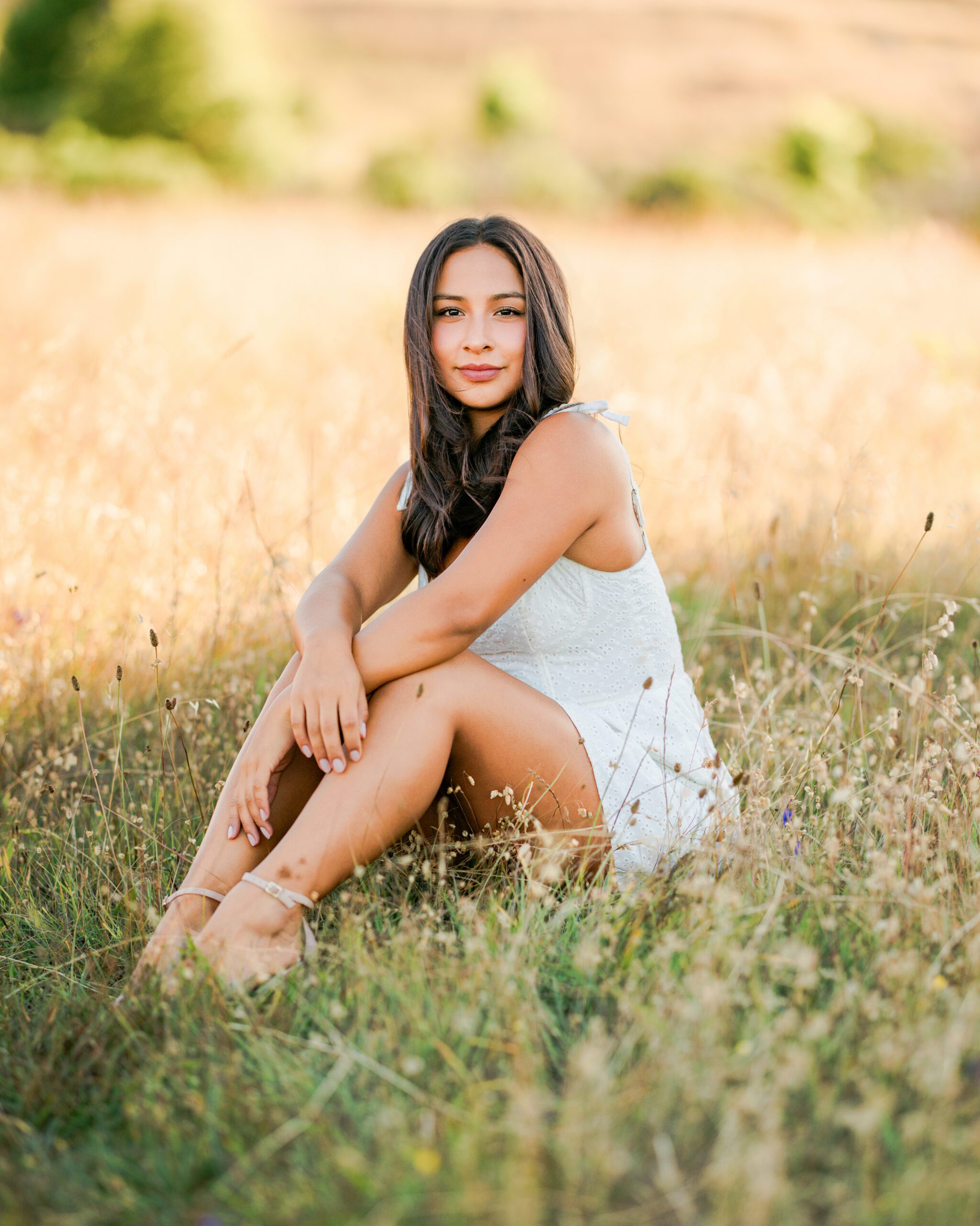 Branson School senior portrait sitting in Marin golden grass during warm summer sunset session