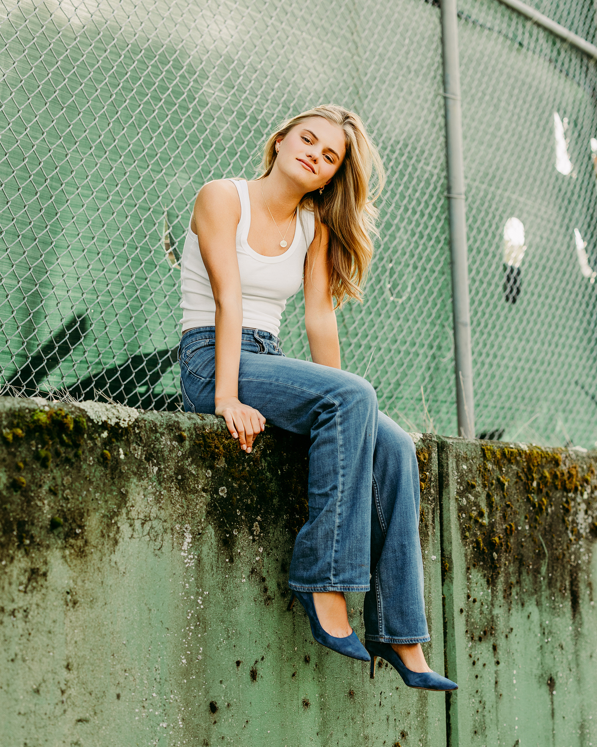 Fashion-inspired senior portrait photographed on a weathered green wall in Marin County