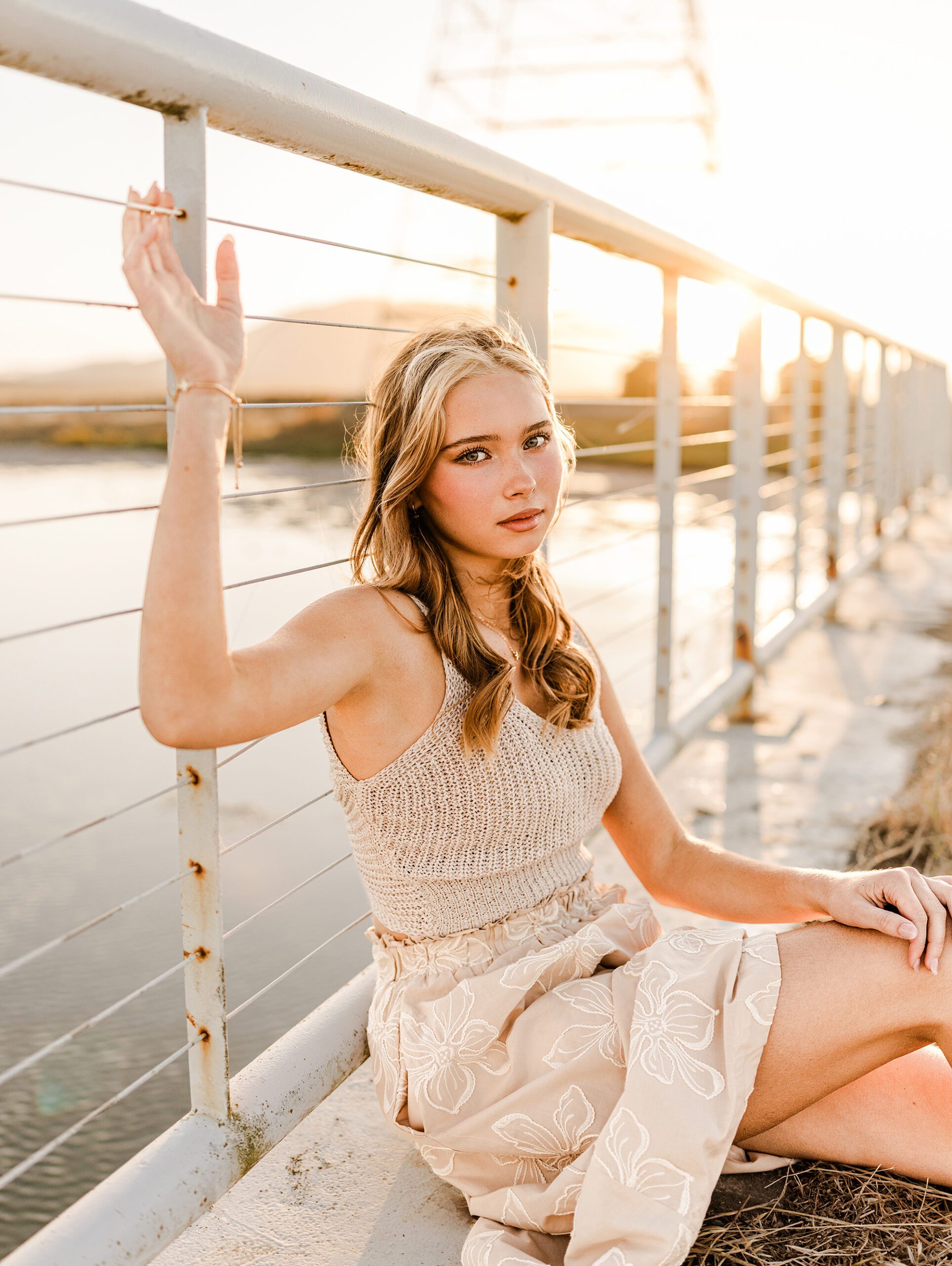 Rising senior Sofia leaning against a bridge railing during her Marin senior portrait session at sunset.
