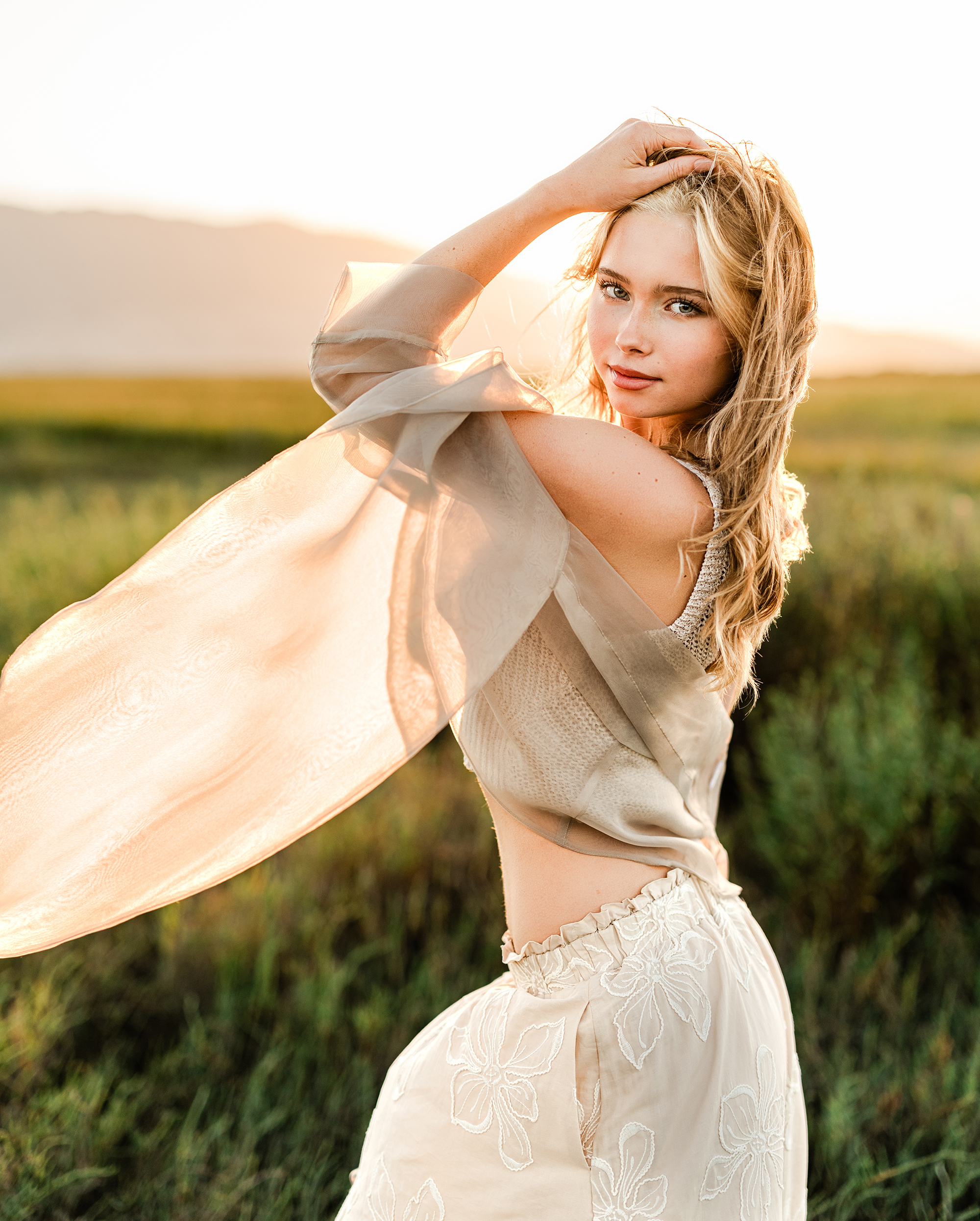 Rising senior Sofia standing in a Marin coastal marsh during her senior portrait session at golden hour.